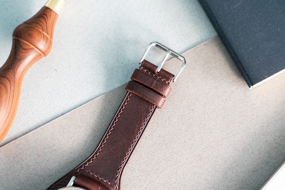 Silver-coloured buckle and paired leather keepers on the dark brown Bund strap.