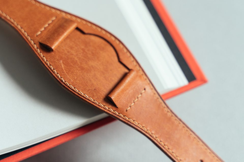 Close-up of the golden tan centre pad and stitched watch attachments.