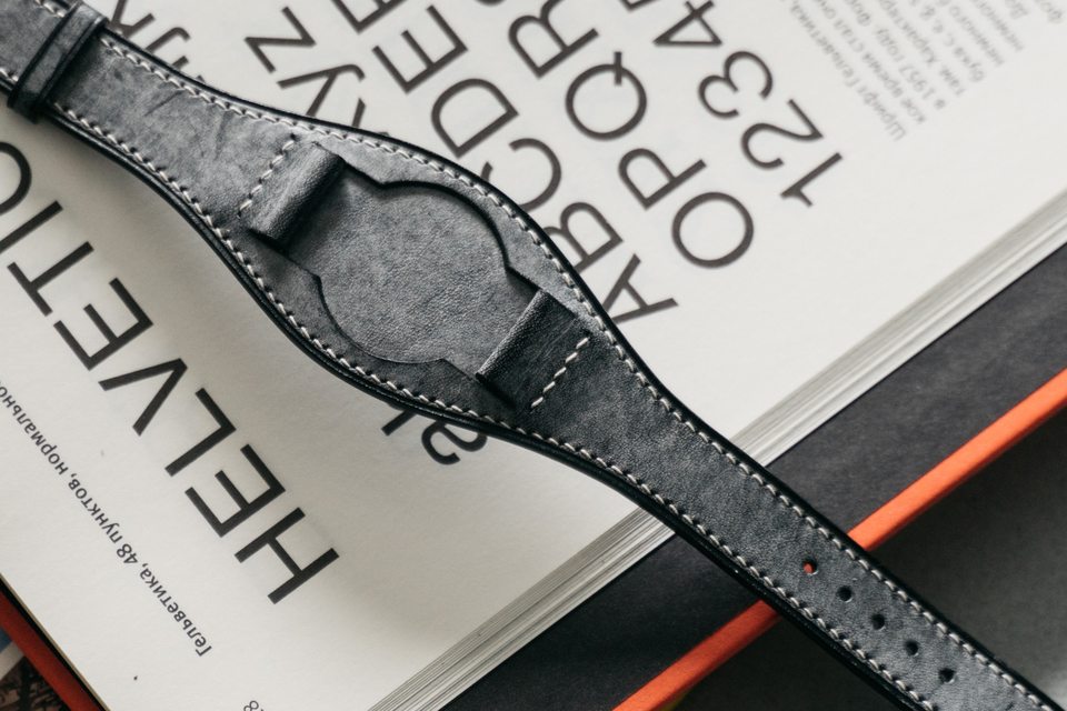 Grey central pad and dark finished edge photographed against printed pages.