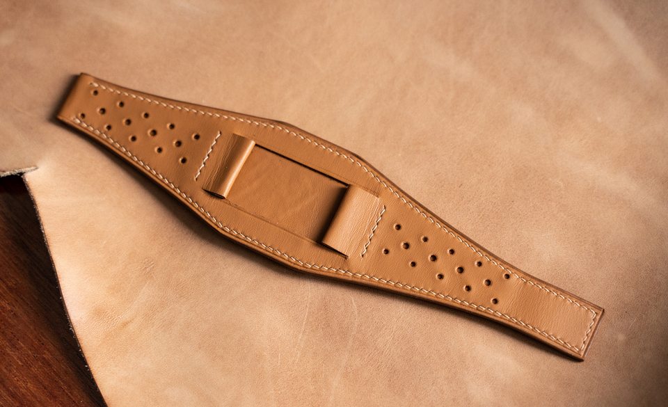 Perforated tan Bund pad laid flat, with folded attachments across its centre.