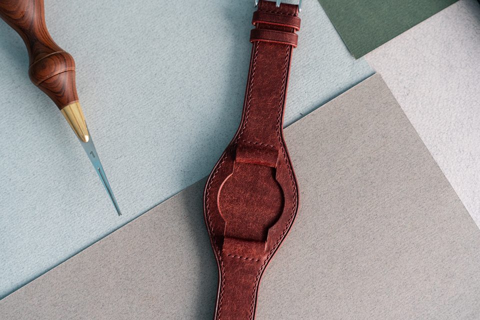 An overhead view of the red strap centre and folded leather watch attachments.