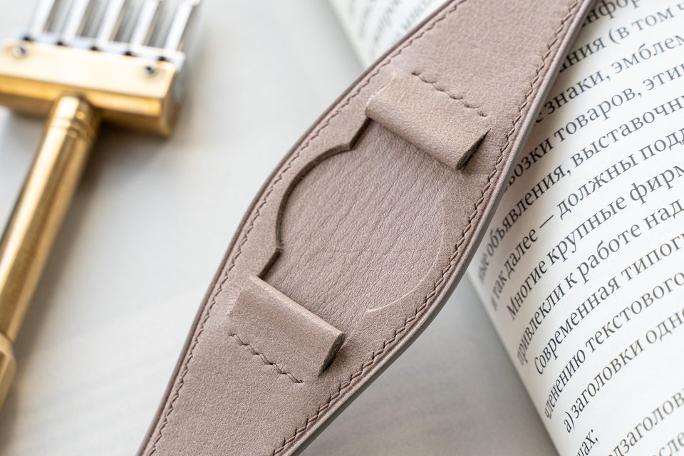Close-up of the pale stone centre pad and folded leather attachments.
